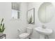 Bright powder room featuring a round mirror, white vessel sink, and decorative succulent print at 17825 Gallup St, Broomfield, CO 80023