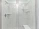 Modern shower features glass doors, tiled walls, built-in shelves, and a comfortable bench seat at 17825 Gallup St, Broomfield, CO 80023