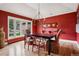 Formal dining room with red walls, hardwood floors, and a contemporary chandelier at 5145 S Logan Dr, Littleton, CO 80121