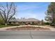 Sprawling ranch-style home with a circular driveway, mature trees, and a well-maintained brick exterior at 5145 S Logan Dr, Littleton, CO 80121