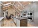 Kitchen with stone countertops, an island with seating, stainless steel appliances, and stone fireplace at 5145 S Logan Dr, Littleton, CO 80121