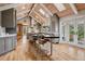 Spacious gourmet kitchen with island seating, stone countertops, stainless appliances, skylights, and vaulted wood ceilings at 5145 S Logan Dr, Littleton, CO 80121