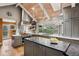 Bright kitchen featuring stone countertops, gas range, gray cabinets, stainless vent hood, and oversized window at 5145 S Logan Dr, Littleton, CO 80121