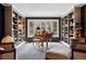 Elegant library with built-in bookshelves, a grand piano, and a bay window offering natural light at 5145 S Logan Dr, Littleton, CO 80121
