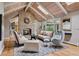Cozy living room featuring a stone fireplace, vaulted wood ceilings, and ample natural light at 5145 S Logan Dr, Littleton, CO 80121