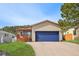 Home featuring a blue garage door, covered porch and manicured lawn, blending comfort and curb appeal at 574 El Paso Rd, Palmer Lake, CO 80133