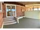 Covered back porch with outdoor carpeting, brick exterior, and steps leading to the yard at 769 S Youngfield Ct, Lakewood, CO 80228