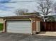 Detached garage with a white door and a brick facade, situated in the backyard of the home at 769 S Youngfield Ct, Lakewood, CO 80228