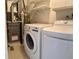 Functional laundry room with modern washer and dryer, utility sink, and shelving at 769 S Youngfield Ct, Lakewood, CO 80228