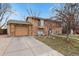 Charming stone facade home with a paved driveway and manicured front yard, perfect for curb appeal at 1390 S Ammons St, Lakewood, CO 80232