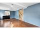 Bright living room with blue accent wall, stairs, and a window, offering a cozy space to relax at 1390 S Ammons St, Lakewood, CO 80232