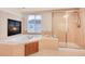 Bathroom featuring a soaking tub with fireplace and a glass-enclosed shower at 7360 Almandine Ct, Castle Rock, CO 80108