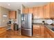 Kitchen with stainless steel appliances, wood cabinets, and tiled countertops for a modern, functional design at 7360 Almandine Ct, Castle Rock, CO 80108