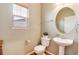 Charming powder room features a pedestal sink, oval mirror, and natural light from a window at 7360 Almandine Ct, Castle Rock, CO 80108