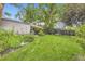 Large, green backyard with mature trees, a charming patio area, and ample space for outdoor activities at 1640 Pontiac St, Denver, CO 80220