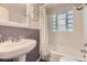 Charming bathroom with unique glass block window and a classic pedestal sink at 1640 Pontiac St, Denver, CO 80220