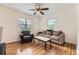 Comfortable living room featuring hardwood floors, a ceiling fan, and ample natural light at 1640 Pontiac St, Denver, CO 80220