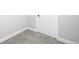 Partially finished basement featuring neutral walls, gray carpet, white trim and a standard white paneled door at 3320 Yukon Ct, Wheat Ridge, CO 80033