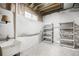Unfinished basement space featuring concrete floors, exposed ceiling and white plastic coated shelving at 3320 Yukon Ct, Wheat Ridge, CO 80033