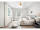 Bright bedroom with dual windows dressed in white curtains, and neutral toned accents at 3320 Yukon Ct, Wheat Ridge, CO 80033