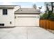Attached two car garage with white carriage doors and concrete driveway at 3320 Yukon Ct, Wheat Ridge, CO 80033