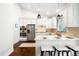 Bright kitchen features stainless steel appliances, white cabinets, pendant lighting, and an eat-in bar at 3320 Yukon Ct, Wheat Ridge, CO 80033