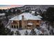 Beautiful aerial view of a grand residence with a snow-covered roof in a serene, wooded setting at 214 Equinox Dr, Castle Rock, CO 80108