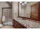 Modern bathroom featuring a glass enclosed shower, granite vanity, and wood accents at 214 Equinox Dr, Castle Rock, CO 80108