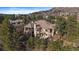 Stunning two-story home featuring a stone chimney, covered patio, and lush landscaping at 214 Equinox Dr, Castle Rock, CO 80108