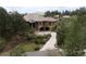 An exterior view shows a house with a lush green yard and mature trees at 214 Equinox Dr, Castle Rock, CO 80108