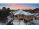 Elegant home exterior with a grand entrance, multiple car garage, and snow-covered landscaping at 214 Equinox Dr, Castle Rock, CO 80108