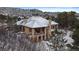 Beautiful two-story home with a stone-accented balcony and a roof covered in fresh winter snow at 214 Equinox Dr, Castle Rock, CO 80108