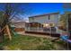 A spacious backyard featuring a deck with a gazebo, play set, lush grass, and a trampoline at 13818 Krameria St, Thornton, CO 80602