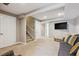 Cozy finished basement with carpet, a gray sofa, and access to stairs and doorways at 13818 Krameria St, Thornton, CO 80602