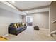 Finished basement features a gray sofa with yellow pillows and recessed ceiling lights at 13818 Krameria St, Thornton, CO 80602