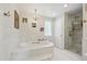 Bright bathroom with a marble-trimmed soaking tub and a glass-enclosed shower at 13818 Krameria St, Thornton, CO 80602