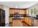 Modern kitchen featuring wood cabinets, a center island, and stainless steel appliances at 13818 Krameria St, Thornton, CO 80602