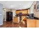 Modern kitchen featuring wood cabinets, a center island, and stainless steel appliances at 13818 Krameria St, Thornton, CO 80602