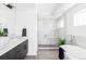 Modern bathroom featuring a glass shower, soaking tub, and dual sink vanity with sleek fixtures at 2090 Eliot St, Denver, CO 80211