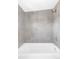 Clean bathtub and shower area with modern gray tiling at 2090 Eliot St, Denver, CO 80211