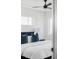 Bright bedroom with a ceiling fan and white linens contrasted by blue decorative pillows at 2090 Eliot St, Denver, CO 80211