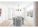 Airy dining room with modern chandelier over a dark wood table and stylish gray upholstered chairs at 2090 Eliot St, Denver, CO 80211