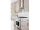 Kitchen view showcasing stainless steel oven and cooktop, light wood cabinetry, and white subway tile backsplash at 2090 Eliot St, Denver, CO 80211