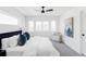 Bright main bedroom featuring plush bedding, modern decor, and a comfortable sitting area by the window at 2090 Eliot St, Denver, CO 80211