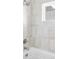 Well lit shower and tub with decorative neutral tile at 2090 Eliot St, Denver, CO 80211