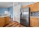 Kitchen features stainless steel refrigerator and wood cabinetry at 11480 Moline St, Commerce City, CO 80640