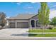 Charming one-story home featuring a three car garage, manicured lawn, and neutral colored exterior at 19802 E 54Th Ave, Denver, CO 80249