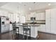 Bright kitchen with white cabinets, stainless steel appliances, granite countertops, and an island with bar seating at 19802 E 54Th Ave, Denver, CO 80249