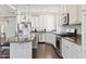 Modern kitchen featuring stainless steel appliances, white cabinetry, granite countertops, and stylish pendant lighting at 19802 E 54Th Ave, Denver, CO 80249