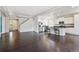 Open-concept living area featuring hardwood floors, modern lighting, and seamless transition to the adjacent kitchen at 19802 E 54Th Ave, Denver, CO 80249